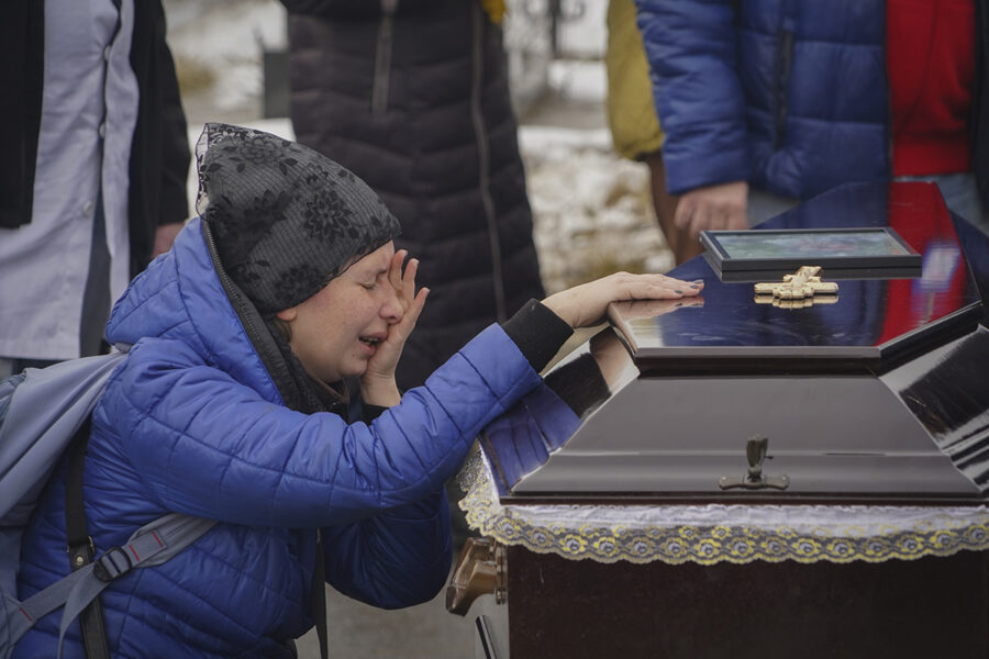 Människor sörjer en familj som dödats av en rysk drönarattack i Charkiv den 12 februari 2024.
