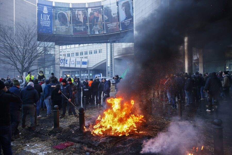 Halm och bildäck brändes under bondeprotester i Bryssel under torsdagen.