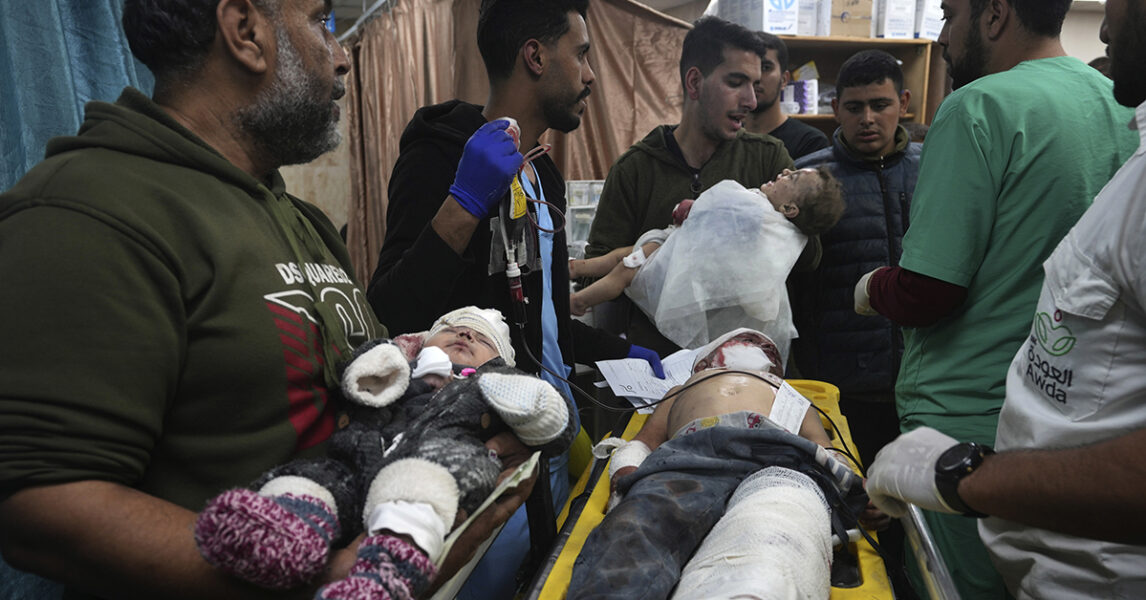 Tre små barn på väg till sjukhuset i Deir al Balah i Gaza, skadade i en israelisk bombattack.