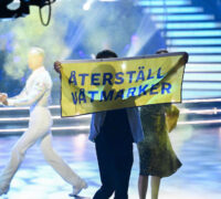 man håller upp banderoll på scenen
