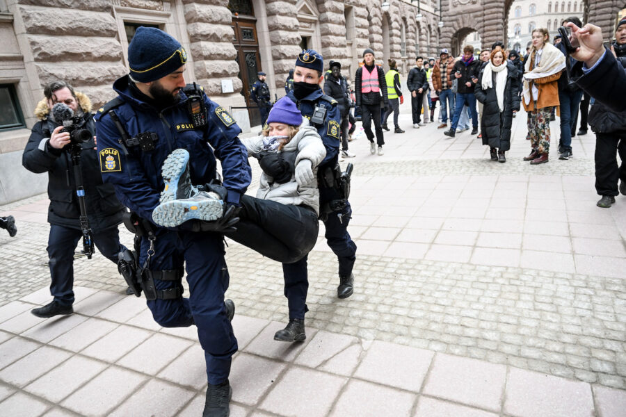 Greta Thunberg bärs bort till en polisbuss.