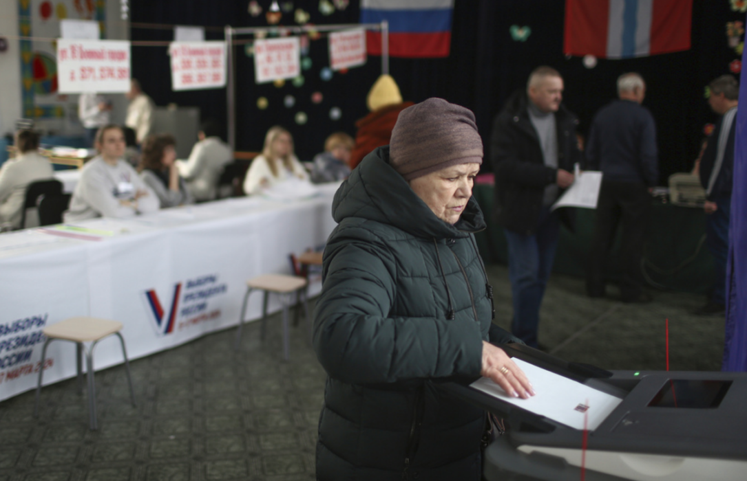 En kvinna lägger ned en valsedel i en vallokal i sibiriska Omsk på fredagen.