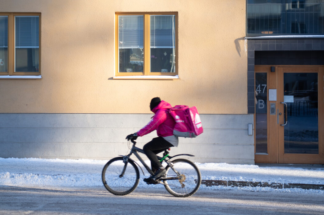 Matbud på cykel i rosa kläder.
