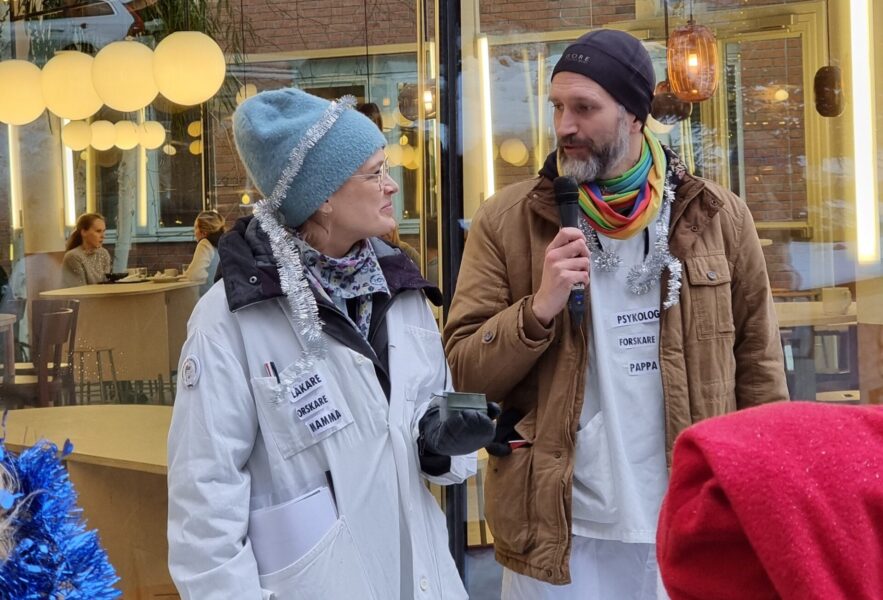 Till höger syns klimataktivisten Björn Paxling vid en tidigare aktion på Folkhälsomyndigheten då aktivisterna bjöd på glögg, pepparkakor och klimatomskrivna julsånger.