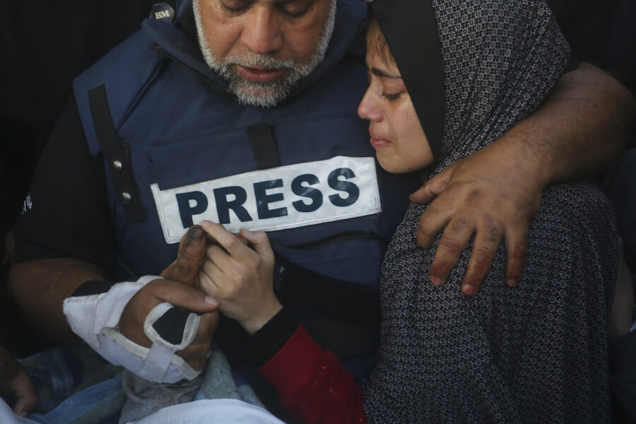 Al Jazeera-journalisten Wael Dahdouh håller sin dödade sons hand vid en begravning i Gaza.