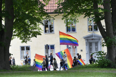 Personer med regnbågsflaggor.
