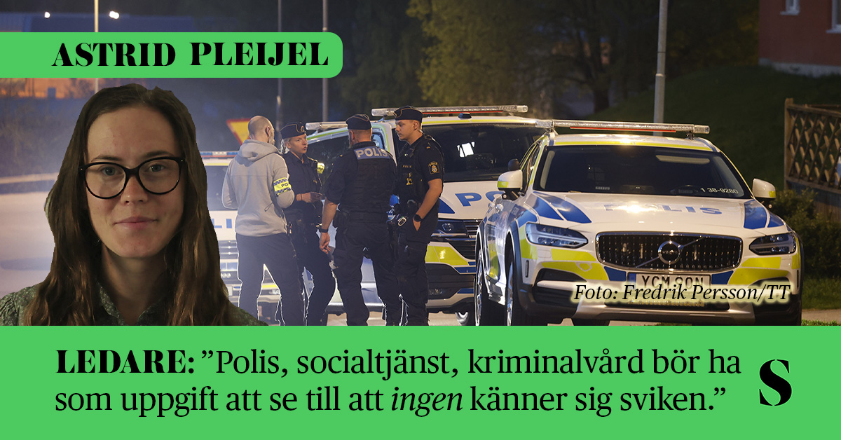 Det är mörkt ute. Utanför en polisbil står en grupp poliser i uniform och talar med en man i grå luvtröja.