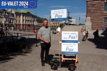 Man på stan intill skyltar som det står Pax på.