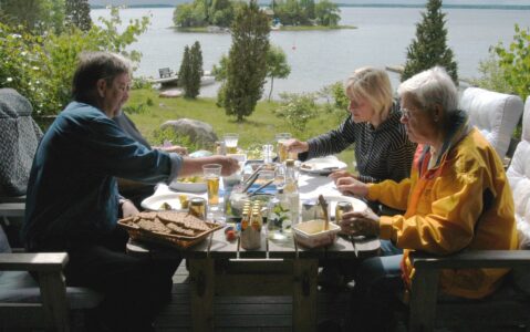 personer som sitter runt ett midsommarbord