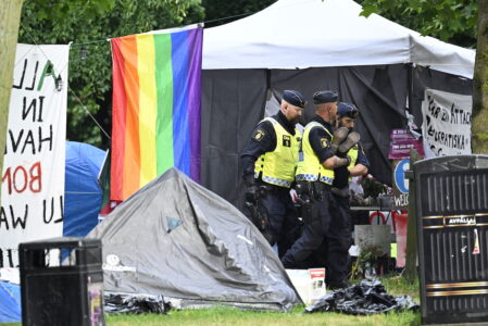 polis bär ut demonstrant från tältläger