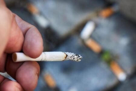 En hand med tänd cigarette