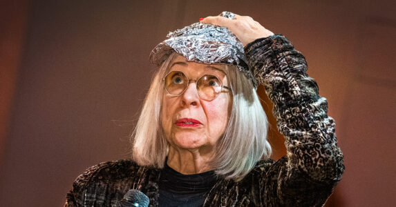 En kvinna trycker ner en bit folie på huvudet så att det liknar en keps.