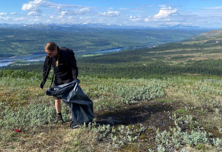 person plockar skräp på fjäll