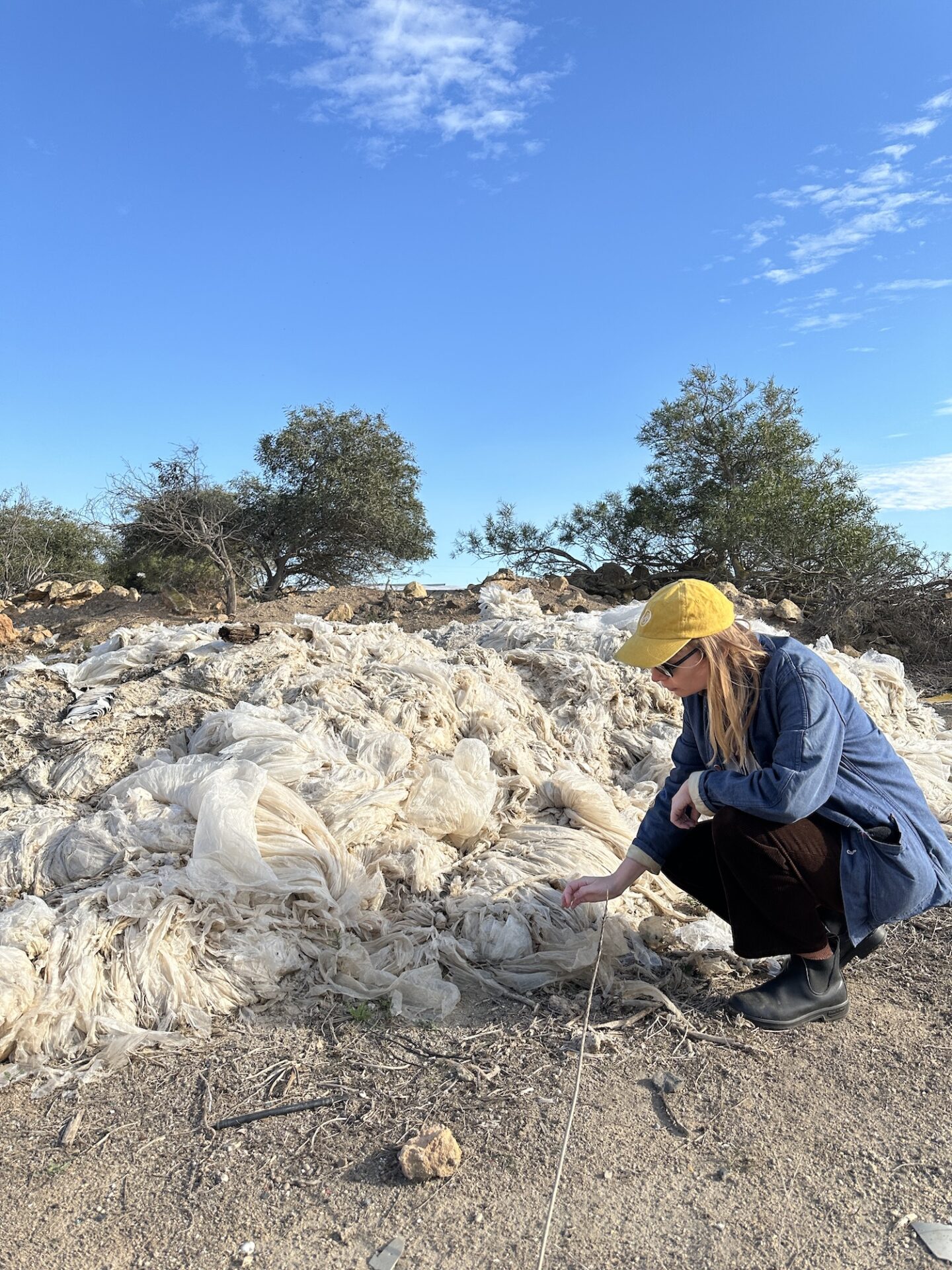 Maja Alskog bredberg sitter på huk framför massor av trasig plast. Maja Alskog bredberg sitter på huk framför massor av trasig plast.
