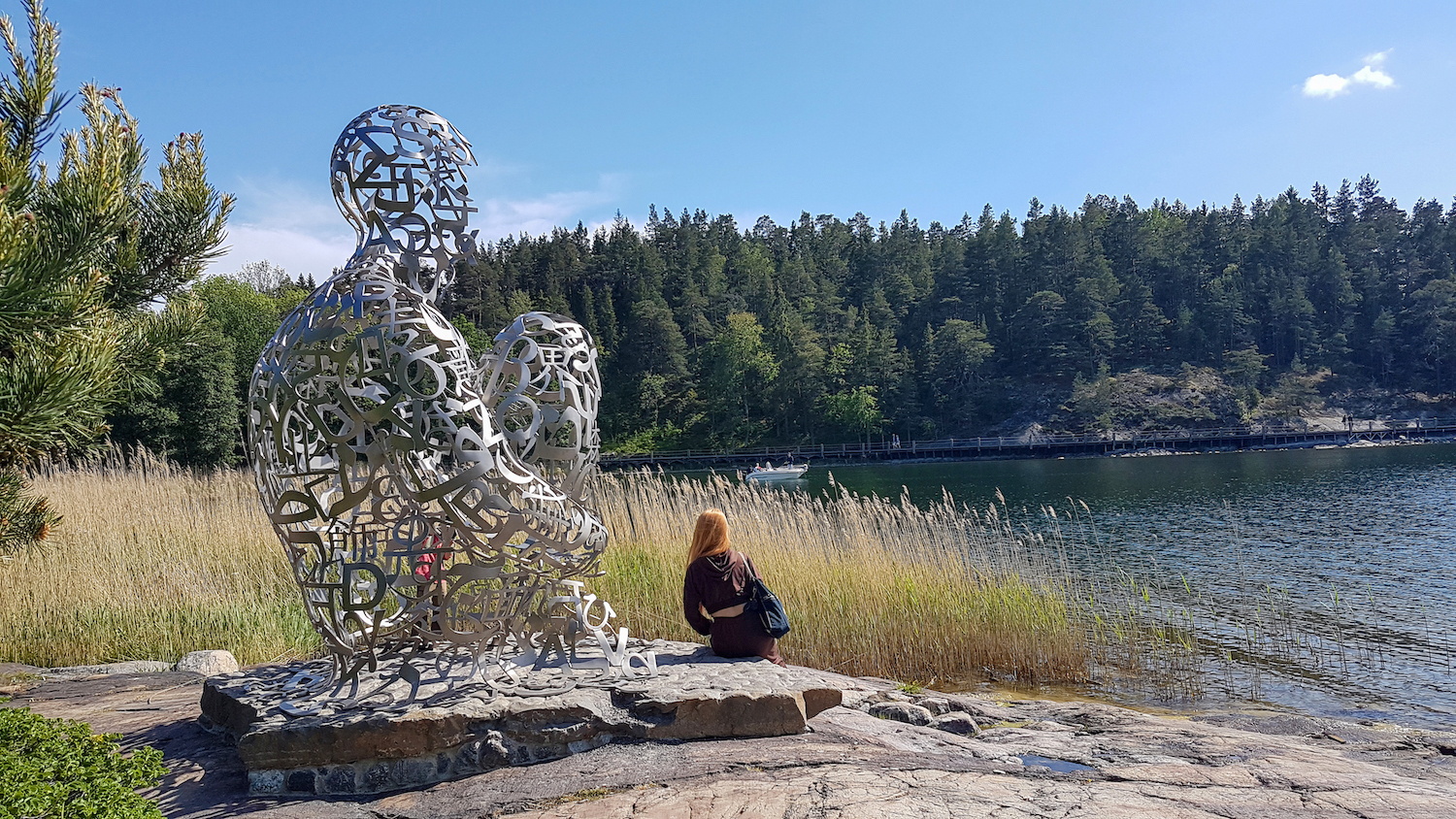 En skulptur med en kvinna som sitter framför. En skulptur med en kvinna som sitter framför.