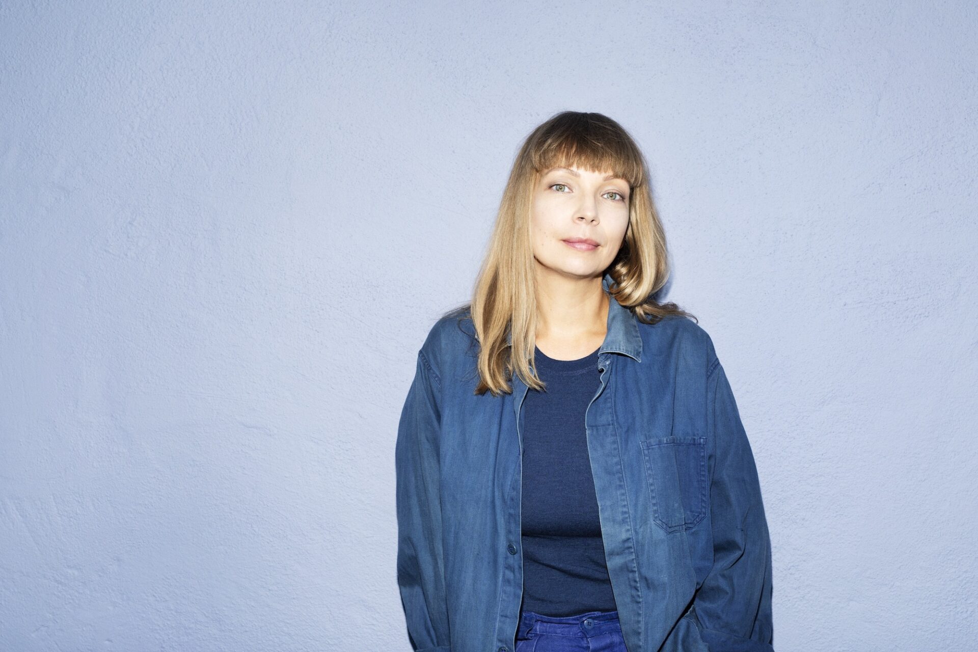 Maja Alskog Bredberg mot blå bakgrund. Maja Alskog Bredberg mot blå bakgrund.
