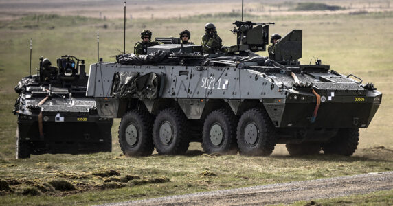 Soldater i två stridsvagnar på ett fält.