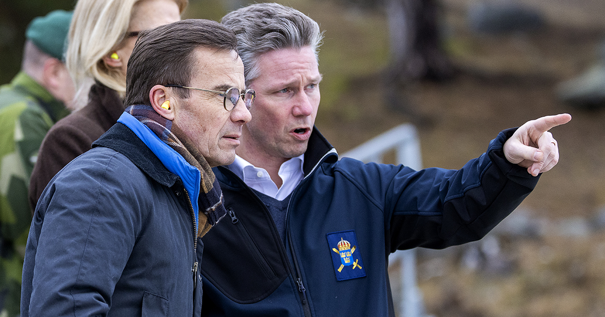Statsminister Ulf Kristersson (M) och försvarsminister Pål Jonson (M) står och spanar vid Berga örlogsbas.