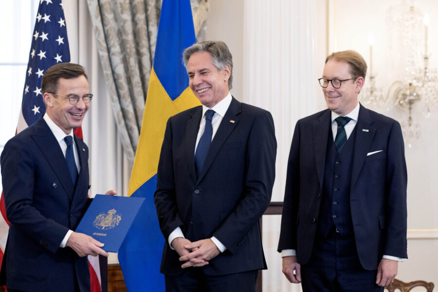 Ulf Kristersson håller upp ett Nato-diplom, bredvid står Anthony Blinken och Tobias Billström.