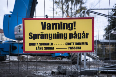 skylt med varning framför bygge