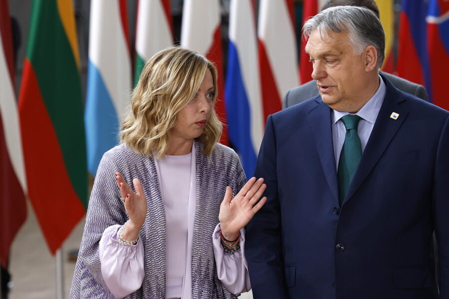 Giorgia Meloni och Viktor Orbán framför flaggor.