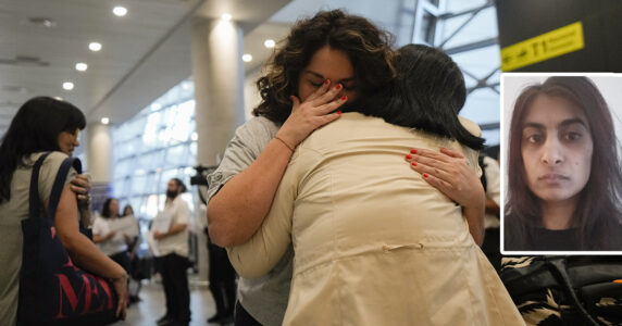 Två kvinnor kramar varandra på en flygplats.