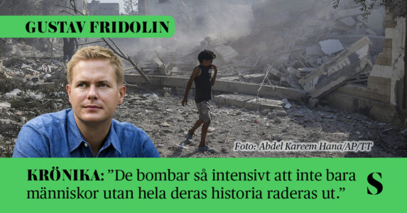 En pojke går bland grus som är bombade hus. Skribenten i förgrunden.