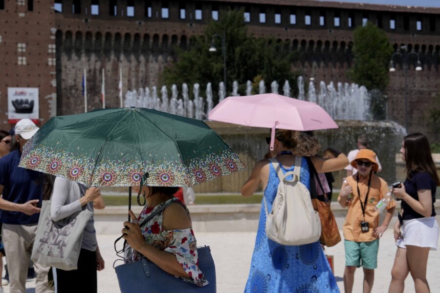 Turister tar skydd från solen i den närmare 40-gradiga värmen i Milano, Italien.