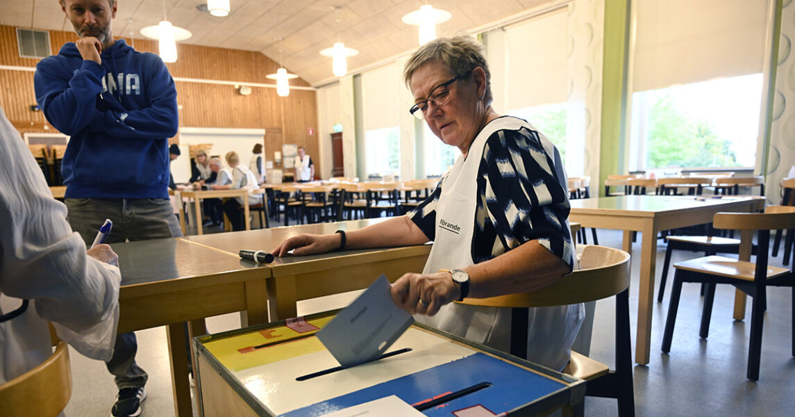 Folk röstar i en vallokal.