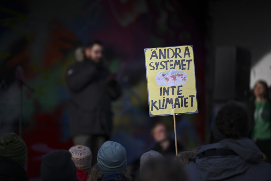 På plakatet står det ”Ändra systemet inte klimatet”