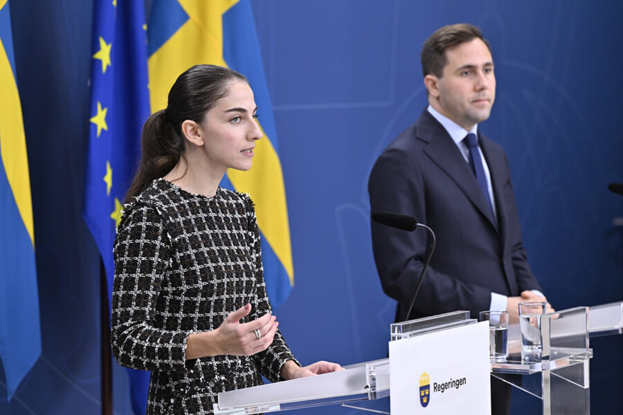 Benjamin Dousa och Romina Pourmokhtari framför svensk och EU-flagga