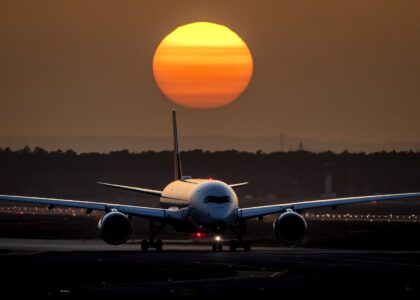 Flygplan på landningsbana i solnedgång.