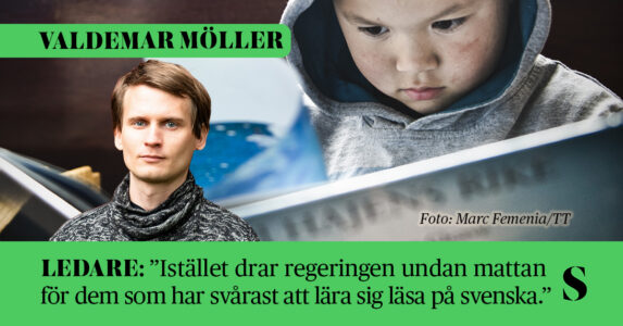 Ett litet barn tittar i en faktabok om hajar