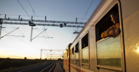 Tåg vid perrong, någon tittar ut.