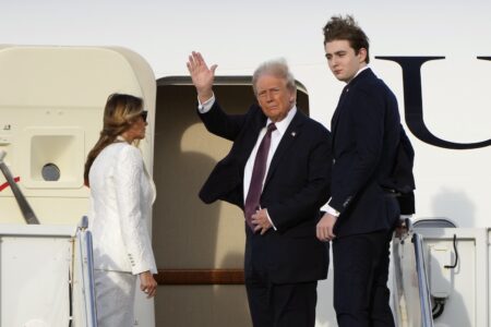 Donald Trump går ombord på ett privatjet tillsammans med Melania Trump och Barron Trump.