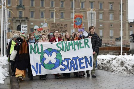 Ungdomar demonstrerar med en banner som säger "Nu stämmer vi staten".