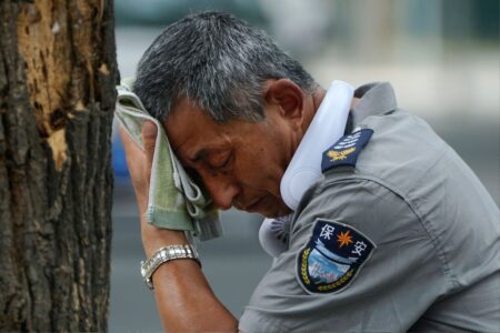 Man torkar sig i pannan med en trasa i Kina.