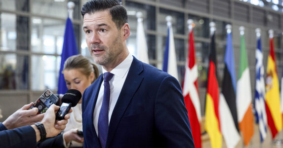 En man framför en rad flaggor.