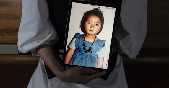 Någon håller i ett foto av en liten flicka.