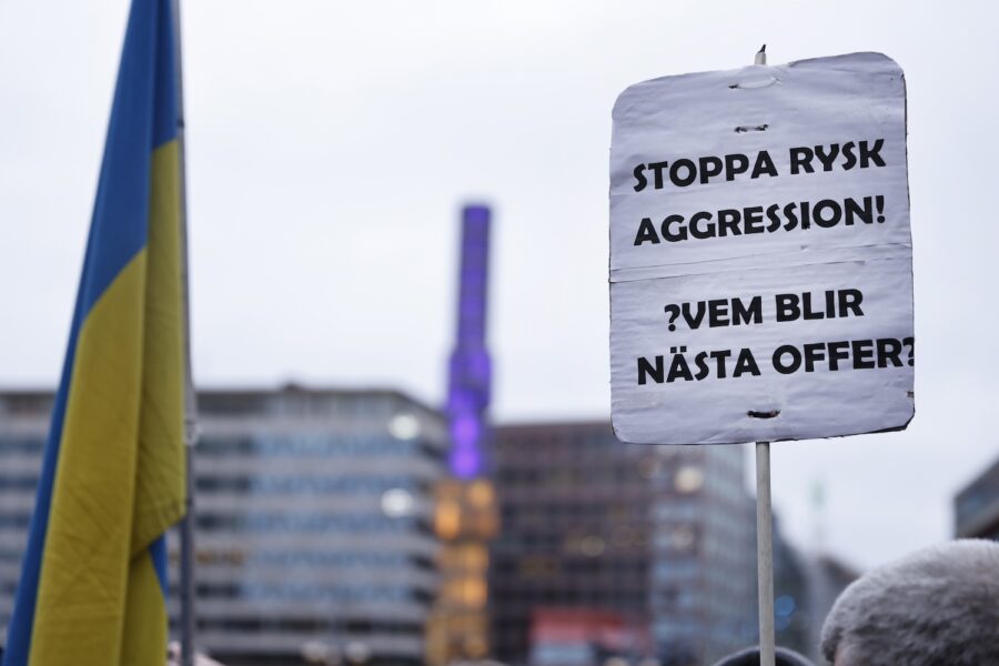 En demonstrant håller skylt med texten: Stoppa rysk aggression! Vem blir nästa offer?