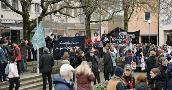 Människor med plakat på ett torg