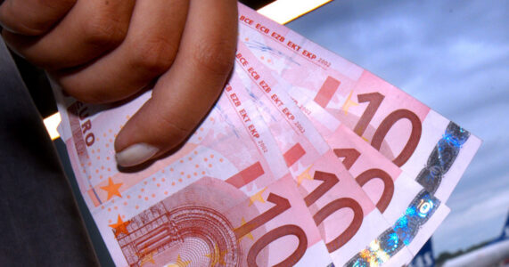 En hand håller i tio-euro-sedlar.