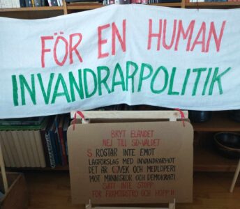 Banderoll och skylt med uppmaning om en human invandringspolitik.