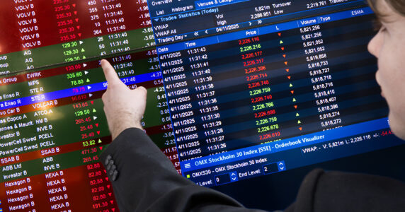 En ung man pekar på en lista på börsen.