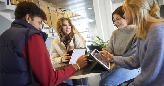 Elever i tonåren sitter i skolan och pratar.