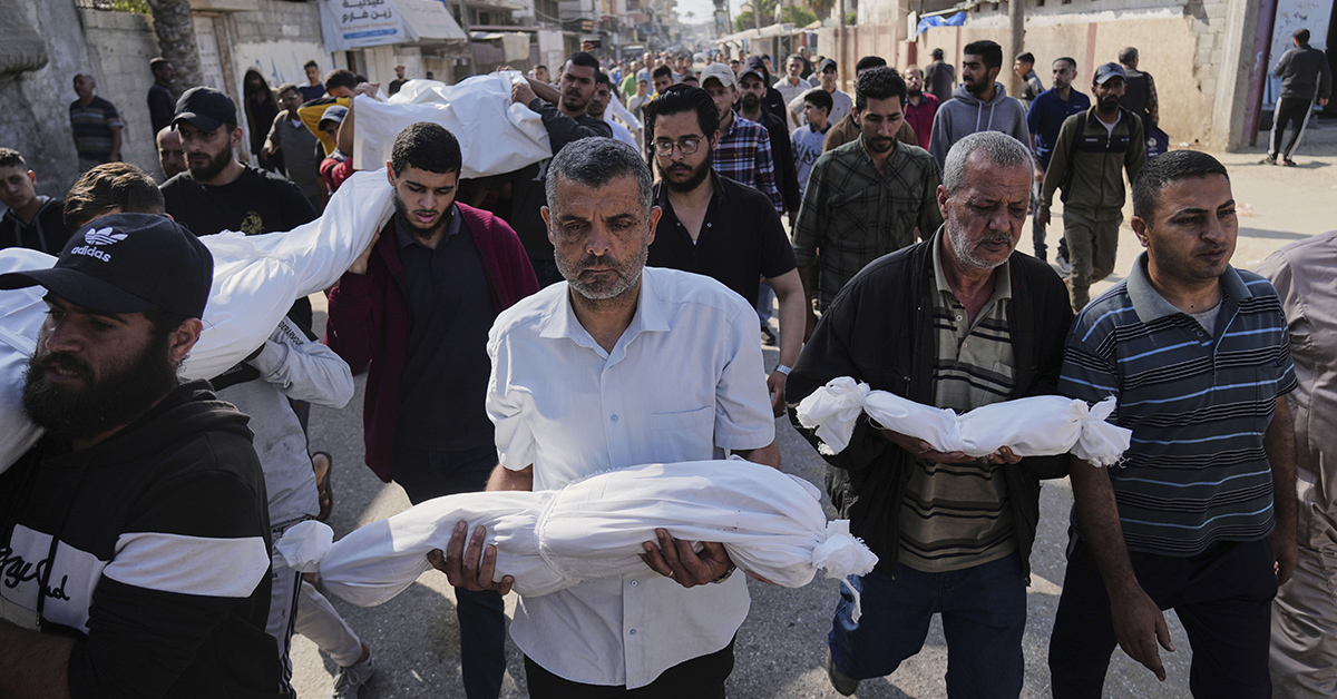 Palestinska män bär bylten med döda barn.