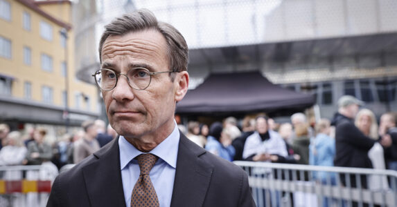 Ulf Kristersson bredvid en demonstration.