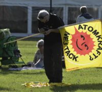 Aktivist med flagga med texten "Atomkraft, nej tack".