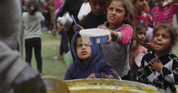 Hungriga barn väntar på mat vid ett soppkök i Gaza.