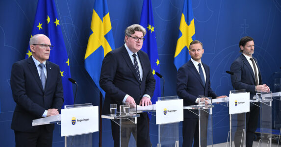 Tre ministrar och en sverigedemokrat håller presskonferens.